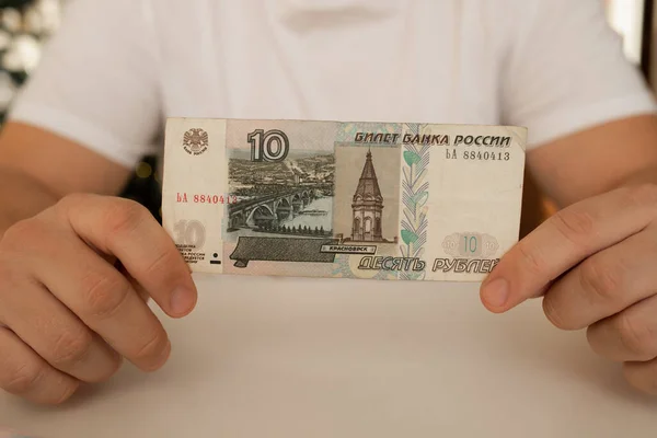 一个特写手里拿着一张面值为10卢布的展开的钞票。俄罗斯货币. — 图库照片