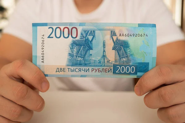 一个特写手里拿着一张有2000美元面值的已展开的钞票 — 图库照片