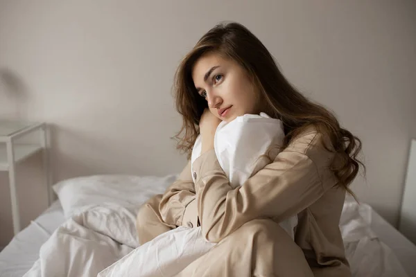 Sad Girl Sits Bed Hugging White Blanket Pensive Face Thoughtful — Stock Photo, Image