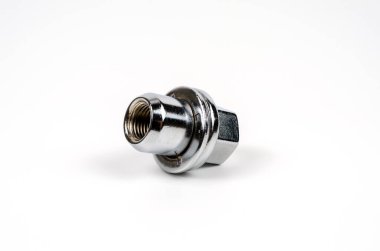 Metal fındık, beyaz arka planda arabanın tekerine yakın çekim yapıyor. araba yedek parça