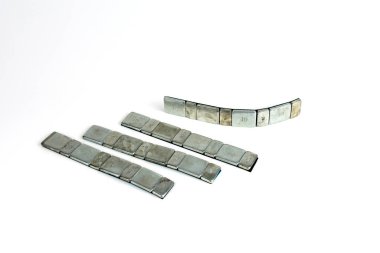 Araç alaşımlı tekerlekleri lastik teçhizatında dengelemek için metal ağırlıklar. beyaz arkaplanda izole