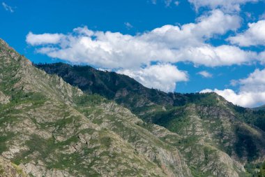 Dağların zirveleri beyaz bulutlu mavi gökyüzüne karşı. Yaz güneşli, güneşli gün