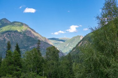 Dağların zirveleri beyaz bulutlu mavi gökyüzüne karşı. Yaz güneşli, güneşli gün