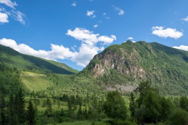 Dağların zirveleri beyaz bulutlu mavi gökyüzüne karşı. Yaz güneşli, güneşli gün