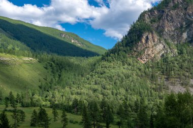 Dağların zirveleri beyaz bulutlu mavi gökyüzüne karşı. Yaz güneşli, güneşli gün