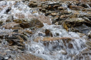 Kayaların arasında küçük bir nehirde yüksek bir şelale