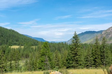 Dağların zirveleri beyaz bulutlu mavi gökyüzüne karşı. Yaz güneşli, güneşli gün