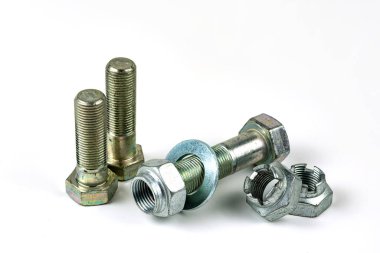 Gümüş metal cıvatalı büyük metal fındıklar. Beyaz arka planda yakın plan. Bir grup somun ve cıvata.