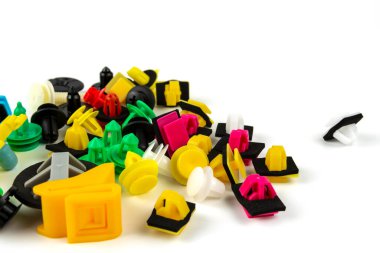 Araba için plastik renkli klipslerin yakın plan çekimi. Soyut arkaplan. Beyaz arka planda izole edilmiş plastik perçinler. Otomatik plastik kelepçeler. Yalıtımlı şarjör veya otomatik plastik toka