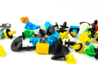 Araba için plastik renkli klipslerin yakın plan çekimi. Soyut arkaplan. Beyaz arka planda izole edilmiş plastik perçinler. Otomatik plastik kelepçeler. Yalıtımlı şarjör veya otomatik plastik toka