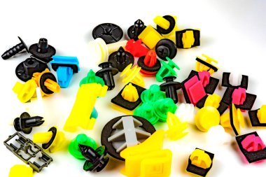 Araba için plastik renkli klipslerin yakın plan çekimi. Soyut arkaplan. Beyaz arka planda izole edilmiş plastik perçinler. Otomatik plastik kelepçeler. Yalıtımlı şarjör veya otomatik plastik toka