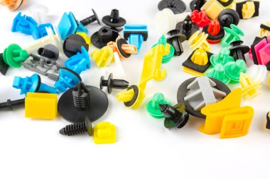 Araba için plastik renkli klipslerin yakın plan çekimi. Soyut arkaplan. Beyaz arka planda izole edilmiş plastik perçinler. Otomatik plastik kelepçeler. Yalıtımlı şarjör veya otomatik plastik toka