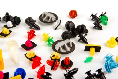 Araba için plastik renkli klipslerin yakın plan çekimi. Soyut arkaplan. Beyaz arka planda izole edilmiş plastik perçinler. Otomatik plastik kelepçeler. Yalıtımlı şarjör veya otomatik plastik toka
