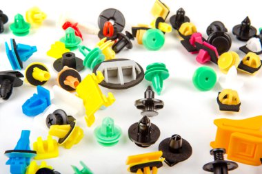 Araba için plastik renkli klipslerin yakın plan çekimi. Soyut arkaplan. Beyaz arka planda izole edilmiş plastik perçinler. Otomatik plastik kelepçeler. Yalıtımlı şarjör veya otomatik plastik toka