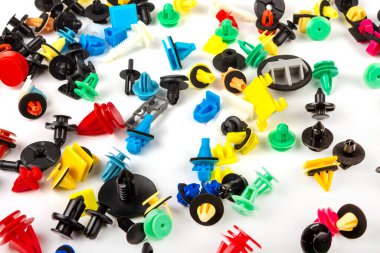 Araba için plastik renkli klipslerin yakın plan çekimi. Soyut arkaplan. Beyaz arka planda izole edilmiş plastik perçinler. Otomatik plastik kelepçeler. Yalıtımlı şarjör veya otomatik plastik toka