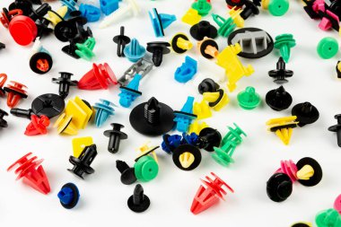 Araba için plastik renkli klipslerin yakın plan çekimi. Soyut arkaplan. Beyaz arka planda izole edilmiş plastik perçinler. Otomatik plastik kelepçeler. Yalıtımlı şarjör veya otomatik plastik toka