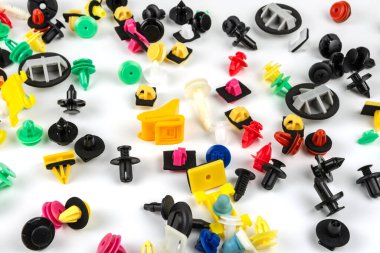 Araba için plastik renkli klipslerin yakın plan çekimi. Soyut arkaplan. Beyaz arka planda izole edilmiş plastik perçinler. Otomatik plastik kelepçeler. Yalıtımlı şarjör veya otomatik plastik toka