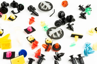 Araba için plastik renkli klipslerin yakın plan çekimi. Soyut arkaplan. Beyaz arka planda izole edilmiş plastik perçinler. Otomatik plastik kelepçeler. Yalıtımlı şarjör veya otomatik plastik toka
