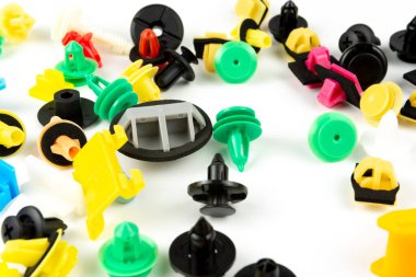 Araba için plastik renkli klipslerin yakın plan çekimi. Soyut arkaplan. Beyaz arka planda izole edilmiş plastik perçinler. Otomatik plastik kelepçeler. Yalıtımlı şarjör veya otomatik plastik toka