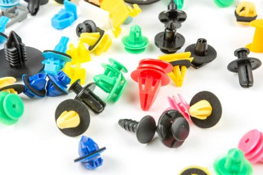 Araba için plastik renkli klipslerin yakın plan çekimi. Soyut arkaplan. Beyaz arka planda izole edilmiş plastik perçinler. Otomatik plastik kelepçeler. Yalıtımlı şarjör veya otomatik plastik toka
