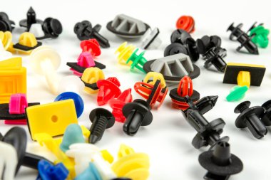 Araba için plastik renkli klipslerin yakın plan çekimi. Soyut arkaplan. Beyaz arka planda izole edilmiş plastik perçinler. Otomatik plastik kelepçeler. Yalıtımlı şarjör veya otomatik plastik toka