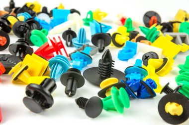 Araba için plastik renkli klipslerin yakın plan çekimi. Soyut arkaplan. Beyaz arka planda izole edilmiş plastik perçinler. Otomatik plastik kelepçeler. Yalıtımlı şarjör veya otomatik plastik toka
