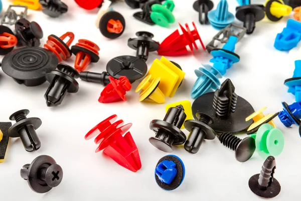 Araba için plastik renkli klipslerin yakın plan çekimi. Soyut arkaplan. Beyaz arka planda izole edilmiş plastik perçinler. Otomatik plastik kelepçeler. Yalıtımlı şarjör veya otomatik plastik toka