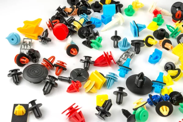 Araba için plastik renkli klipslerin yakın plan çekimi. Soyut arkaplan. Beyaz arka planda izole edilmiş plastik perçinler. Otomatik plastik kelepçeler. Yalıtımlı şarjör veya otomatik plastik toka