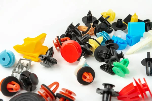 Araba için plastik renkli klipslerin yakın plan çekimi. Soyut arkaplan. Beyaz arka planda izole edilmiş plastik perçinler. Otomatik plastik kelepçeler. Yalıtımlı şarjör veya otomatik plastik toka