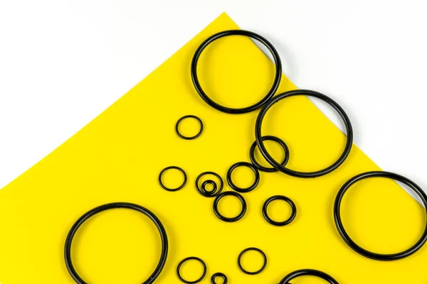 Zwarte Hydraulische Pneumatische Ringen Verschillende Maten Een Gele Witte Achtergrond — Stockfoto