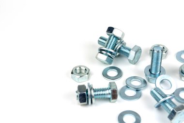 Various silver metal bolts. Fastening bolts with washers and nuts on a white background close-up. Copy space.