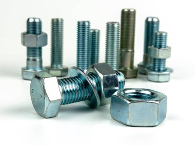 Several large silver metal bolts. Bolts, nuts and washers on a white background close up