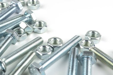 Various silver metal bolts. Fastening bolts with washers and nuts on a white background close-up. Copy space.