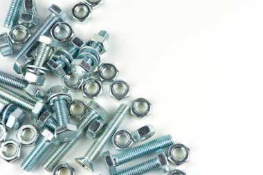 Various silver metal bolts. Fastening bolts with washers and nuts on a white background close-up. Copy space.