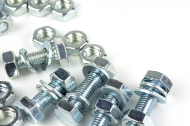 Various silver metal bolts. Fastening bolts with washers and nuts on a white background close-up. Copy space.
