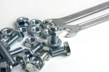 several open-end metal wrenches for working with bolts. Close-up on a white background. Silver metal fixing bolts and nuts. Copy space