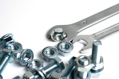 several open-end metal wrenches for working with bolts. Close-up on a white background. Silver metal fixing bolts and nuts. Copy space