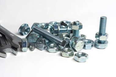 several open-end metal wrenches for working with bolts. Close-up on a white background. Silver metal fixing bolts and nuts. Copy space
