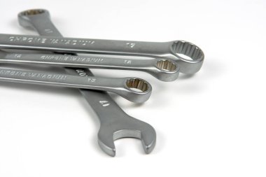 several open metal keys are in a pile. Close-up on white background