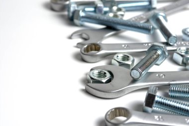 several open-end metal wrenches for working with bolts. Close-up on a white background. Silver metal fixing bolts and nuts. Copy space