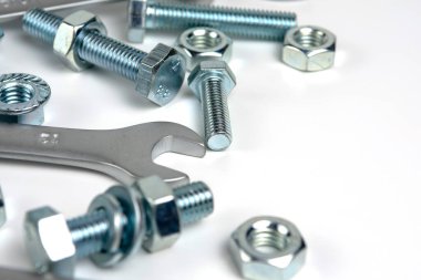several open-end metal wrenches for working with bolts. Close-up on a white background. Silver metal fixing bolts and nuts. Copy space