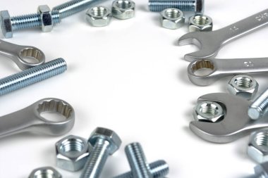 several open-end metal wrenches for working with bolts. Close-up on a white background. Silver metal fixing bolts and nuts. Copy space
