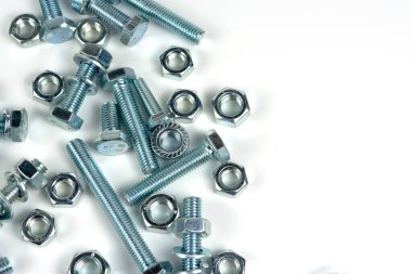 Gümüş metalden yapılmış fındıklı birkaç cıvata. Beyaz bir arkaplanda yakın plan izole edilmiş. Boşluğu kopyala