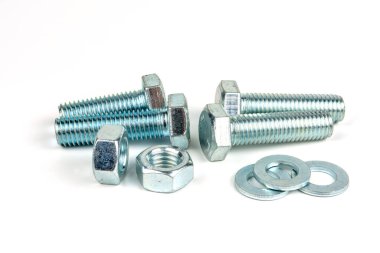 Beyaz arka planda vidaları ve fındıkları olan birkaç metal cıvata. yakın plan