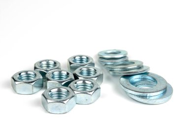 Gümüş metalden yapılmış birkaç fındık ve çamaşır makinesi. beyaz arkaplanda izole