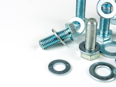 Metal civatalar ve yuvarlak temizleyiciler beyaz arka planda. Boşluğu kopyala