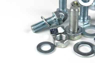 Metal cıvatalar ve fındıklar. Yuvarlak temizleyiciler beyaz arka planda.
