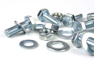 Metal cıvatalar ve fındıklar. Yuvarlak temizleyiciler beyaz arka planda.