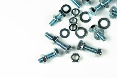 Metal cıvatalar ve fındıklar. Beyaz arka planda yuvarlak temizleyiciler var. Boşluğu kopyala