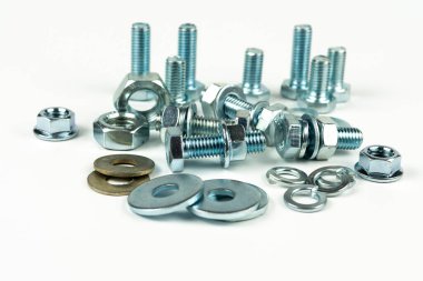 Metal cıvatalar ve fındıklar. Yuvarlak temizleyiciler beyaz arka planda.